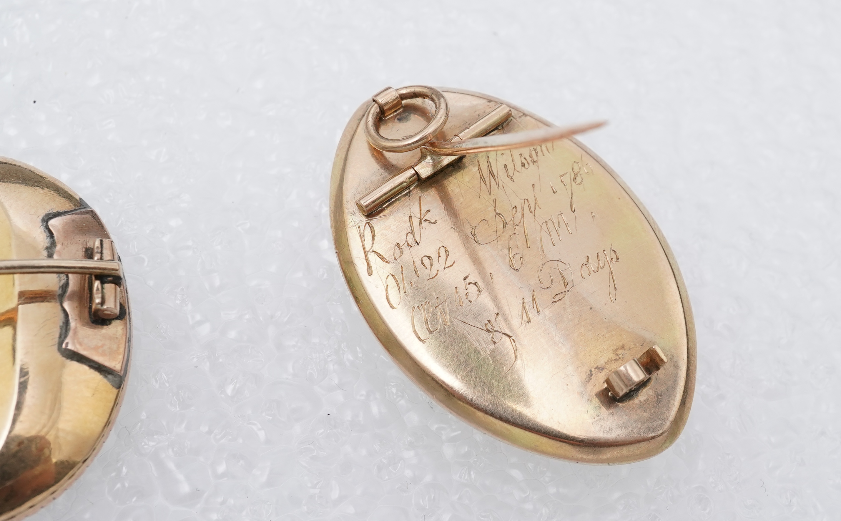A George III ivory mourning brooch, circa 1786, and a feather work brooch, 19th century